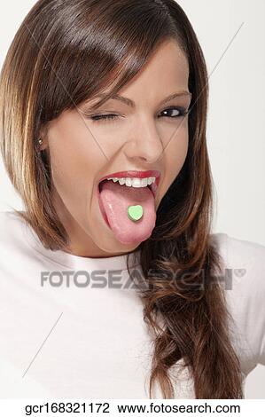 Woman winking with a mint candy on her tongue View Large Photo Image Stock Image - Woman winking with a mint candy on her tongue. Fotosearch