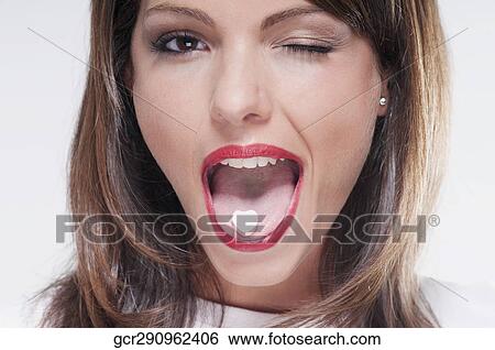Woman winking with mint candy on her tongue View Large Photo Image Stock Photograph - Woman winking with mint candy on her tongue. Fotosearch