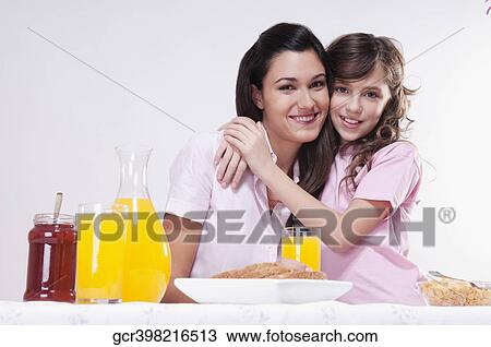Woman with her daughter at a breakfast table View Large Photo Image Stock Image - Woman with her daughter at a breakfast table. Fotosearch