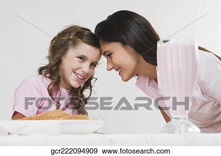 Woman with her daughter at a breakfast table View Large Photo Image Stock Photo - Woman with her daughter at a breakfast table. Fotosearch