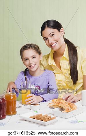 Woman with her daughter at a breakfast table View Large Photo Image Stock Photography - Woman with her daughter at a breakfast table. Fotosearch