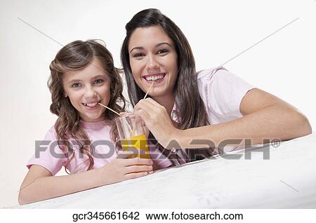 Woman with her daughter drinking juice View Large Photo Image Stock Image - Woman with her daughter drinking juice. Fotosearch