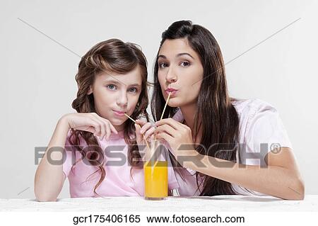 Stock Photography - Woman with her daughter drinking juice. Fotosearch