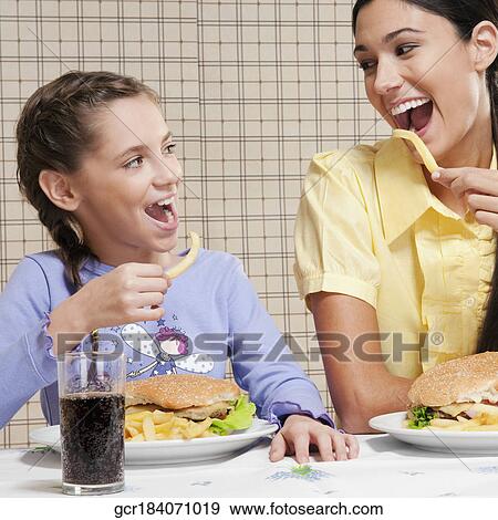 Woman with her daughter having breakfast View Large Photo Image Stock Photo - Woman with her daughter having breakfast. Fotosearch