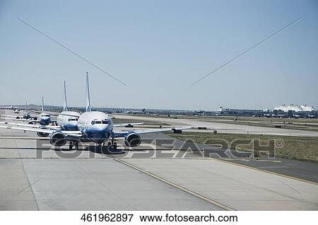 Airplanes in a row on a runway View Large Photo Image Stock Photo - Airplanes in a row on a runway. Fotosearch