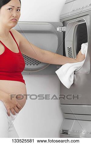 Annoyed pregnant woman washing clothes View Large Photo Image Stock Image - Annoyed pregnant woman washing clothes. Fotosearch