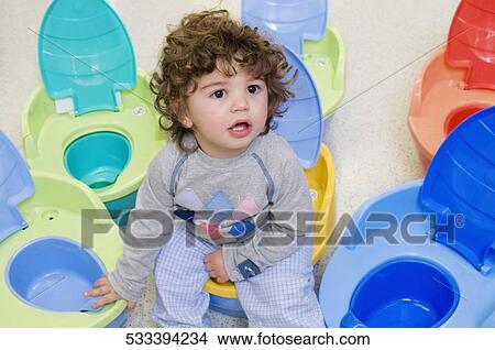 Baby boy sitting on a pot seat in a supermarket View Large Photo Image Picture - Baby boy sitting on a pot seat in a supermarket. Fotosearch