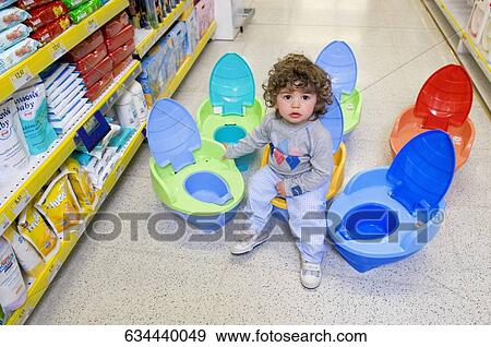 Baby boy sitting on a toilet bowl in a supermarket View Large Photo Image Stock Photo - Baby boy sitting on a toilet bowl in a supermarket. Fotosearch