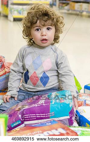 Baby boy sitting with diaper packets around him in a supermarket View Large Photo Image Stock Photography - Baby boy sitting with diaper packets around him in a supermarket. Fotosearch