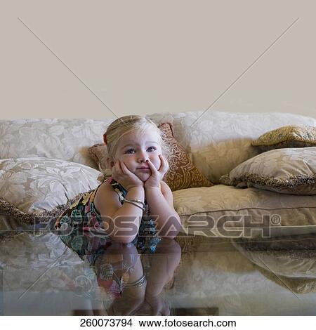 Baby girl leaning on elbows on the glass table View Large Photo Image Picture - Baby girl leaning on elbows on the glass table. Fotosearch