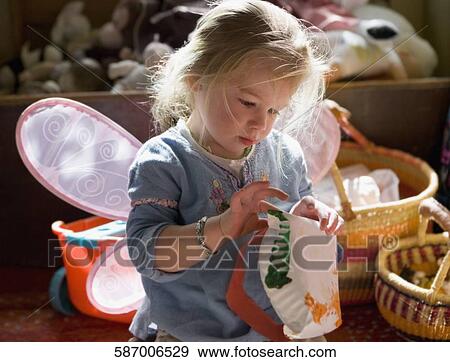 Stock Photo - Baby girl painting a paper plate. Fotosearch