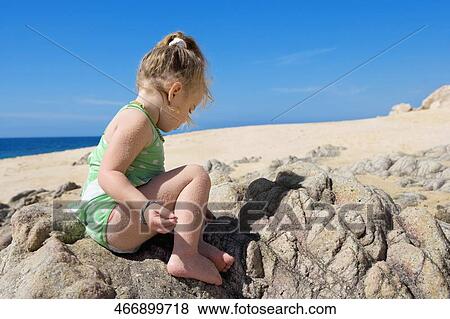 Baby girl sitting on a rock, Cabo San Lucas, Mexico View Large Photo Image Stock Photo - Baby girl sitting on a rock, Cabo San Lucas, Mexico. Fotosearch