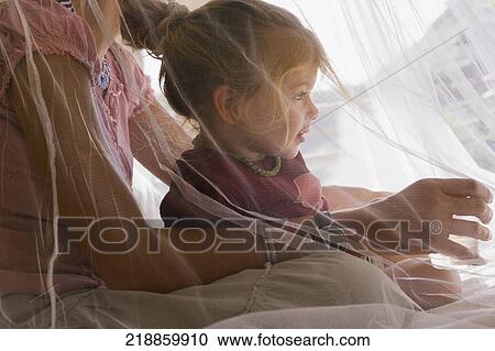 Baby girl sitting with her mother in the bedroom View Large Photo Image Stock Image - Baby girl sitting with her mother in the bedroom. Fotosearch