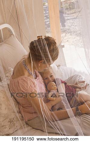 Stock Image - Baby girl with her mother in the bedroom. Fotosearch