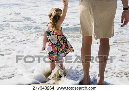Picture - Baby girl with her mother walking on the beach, Cabo San Lucas, Mexico. Fotosearch