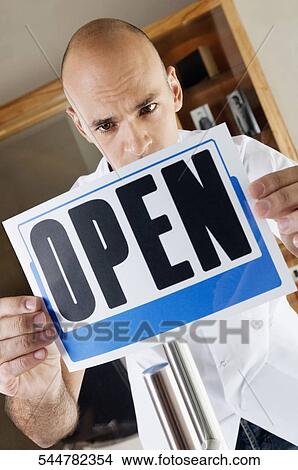 Barber holding an Open signboard View Large Photo Image Picture - Barber holding an Open signboard. Fotosearch