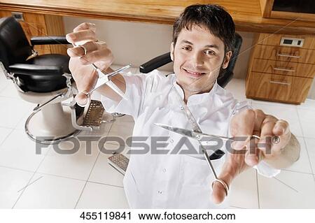 Barber in a salon holding scissors View Large Photo Image Stock Image - Barber in a salon holding scissors. Fotosearch