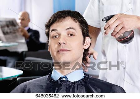 Barber spraying water on a man's hair View Large Photo Image Stock Image - Barber spraying water on a man's hair. Fotosearch
