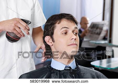Barber spraying water on a man's hair View Large Photo Image Stock Photo - Barber spraying water on a man's hair. Fotosearch