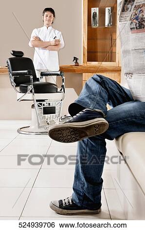 Barber standing near a chair in a salon View Large Photo Image Stock Photograph - Barber standing near a chair in a salon. Fotosearch