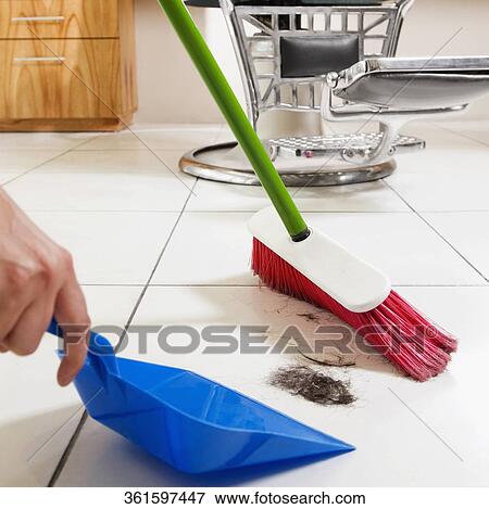 Stock Photo - Barber sweeping in a salon. Fotosearch