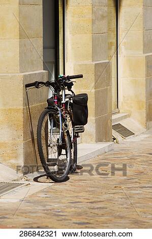 Stock Image - Bicycle parked against a wall. Fotosearch
