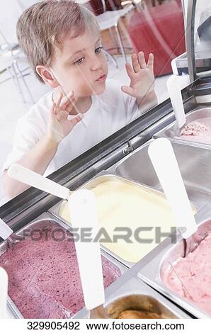 Stock Image - Boy choosing ice cream in an ice cream parlor. Fotosearch