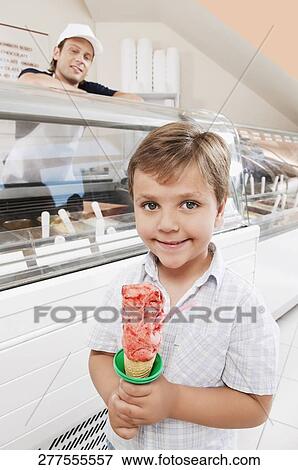Stock Photo - Boy holding an ice cream and smiling. Fotosearch