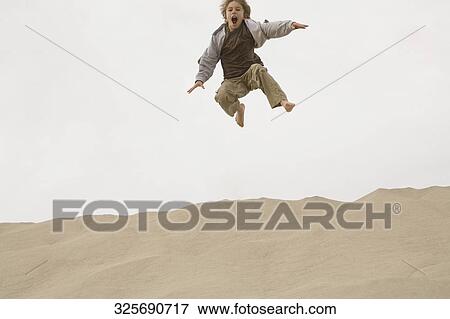 Boy jumping on the beach View Large Photo Image Stock Photo - Boy jumping on the beach. Fotosearch