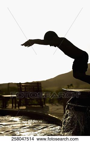 Picture - Boy preparing to jump into a swimming pool. Fotosearch