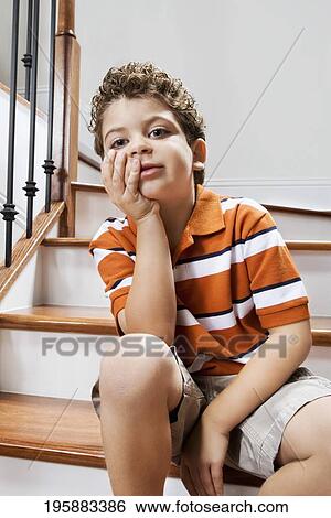 Boy sitting on a staircase and thinking View Large Photo Image Stock Photograph - Boy sitting on a staircase and thinking. Fotosearch