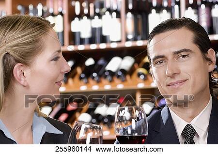 Business couple holding wine glasses and smiling View Large Photo Image Picture - Business couple holding wine glasses and smiling. Fotosearch