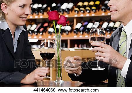 Business couple holding wine glasses and smiling View Large Photo Image Stock Photo - Business couple holding wine glasses and smiling. Fotosearch