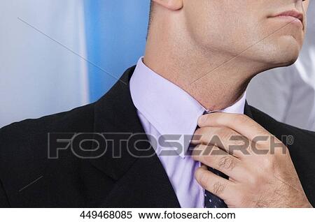 Businessman adjusting his tie View Large Photo Image Stock Photography - Businessman adjusting his tie. Fotosearch