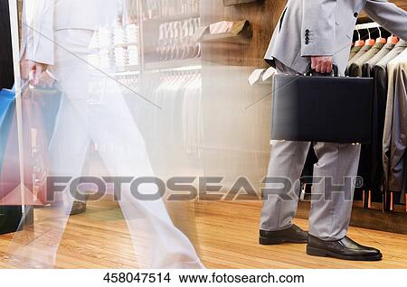 Businessman and a woman shopping in a clothing store View Large Photo Image Picture - Businessman and a woman shopping in a clothing store. Fotosearch