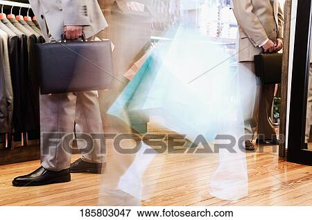 Businessman and a woman shopping in a clothing store View Large Photo Image Stock Photo - Businessman and a woman shopping in a clothing store. Fotosearch