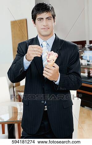 Picture - Businessman eating an ice cream. Fotosearch