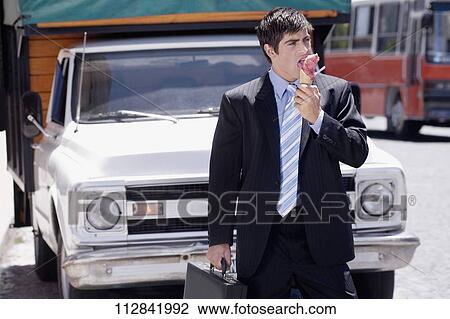 Stock Image - Businessman eating an ice cream. Fotosearch