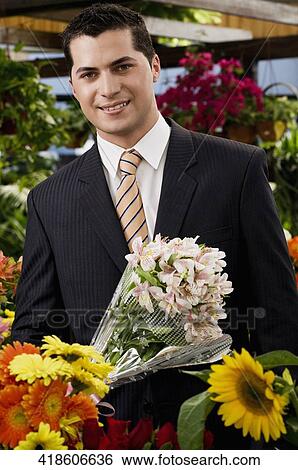 Businessman holding a bouquet of flowers View Large Photo Image Stock Photograph - Businessman holding a bouquet of flowers. Fotosearch
