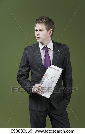 Businessman holding a newspaper View Large Photo Image Stock Photo - Businessman holding a newspaper. Fotosearch