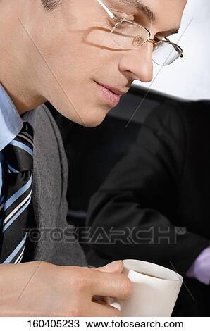 Stock Image - Businessman holding a tea cup. Fotosearch