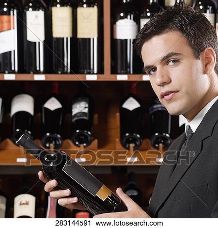 Businessman holding a wine bottle View Large Photo Image Stock Image - Businessman holding a wine bottle. Fotosearch