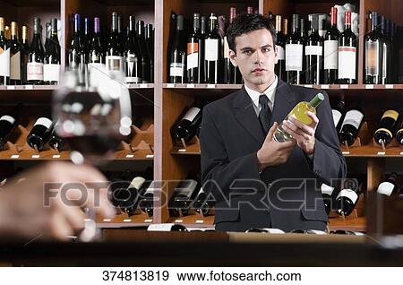 Businessman holding a wine bottle View Large Photo Image Stock Photo - Businessman holding a wine bottle. Fotosearch