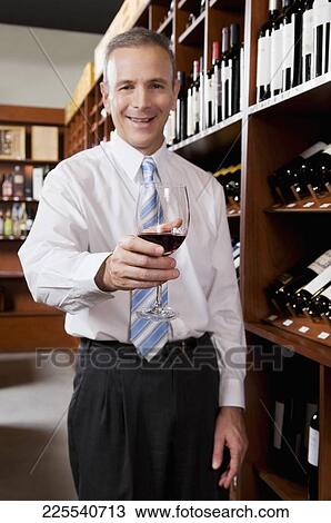 Businessman holding a wine glass View Large Photo Image Stock Image - Businessman holding a wine glass. Fotosearch