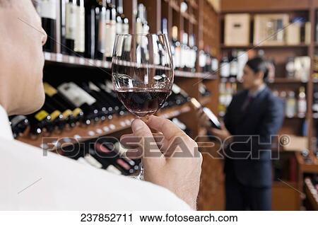 Businessman holding a wine glass View Large Photo Image Stock Image - Businessman holding a wine glass. Fotosearch