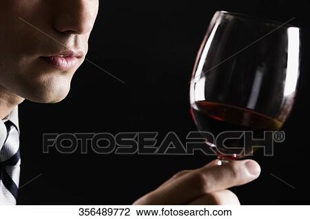 Businessman holding a wine glass View Large Photo Image Stock Image - Businessman holding a wine glass. Fotosearch