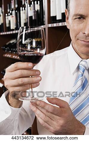 Businessman holding a wine glass View Large Photo Image Stock Image - Businessman holding a wine glass. Fotosearch