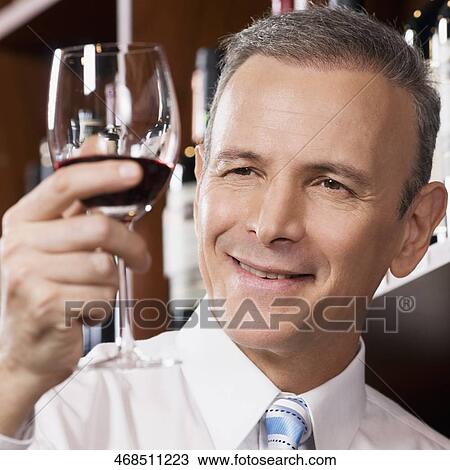 Businessman holding a wine glass View Large Photo Image Stock Image - Businessman holding a wine glass. Fotosearch