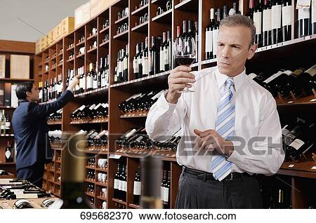 Businessman holding a wine glass View Large Photo Image Stock Image - Businessman holding a wine glass. Fotosearch