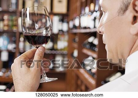 Businessman holding a wine glass View Large Photo Image Stock Photography - Businessman holding a wine glass. Fotosearch